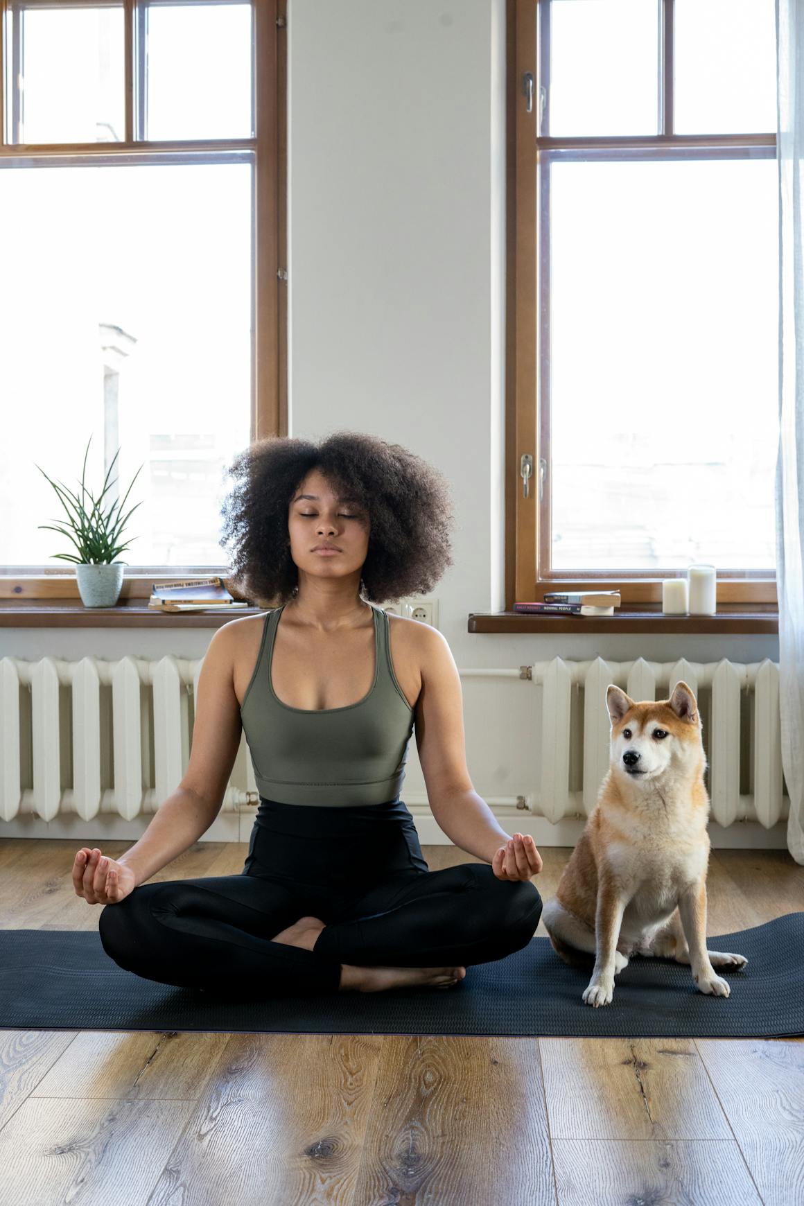 A mom practices yoga meditation at home with her dog, creating a calm and peaceful environment.