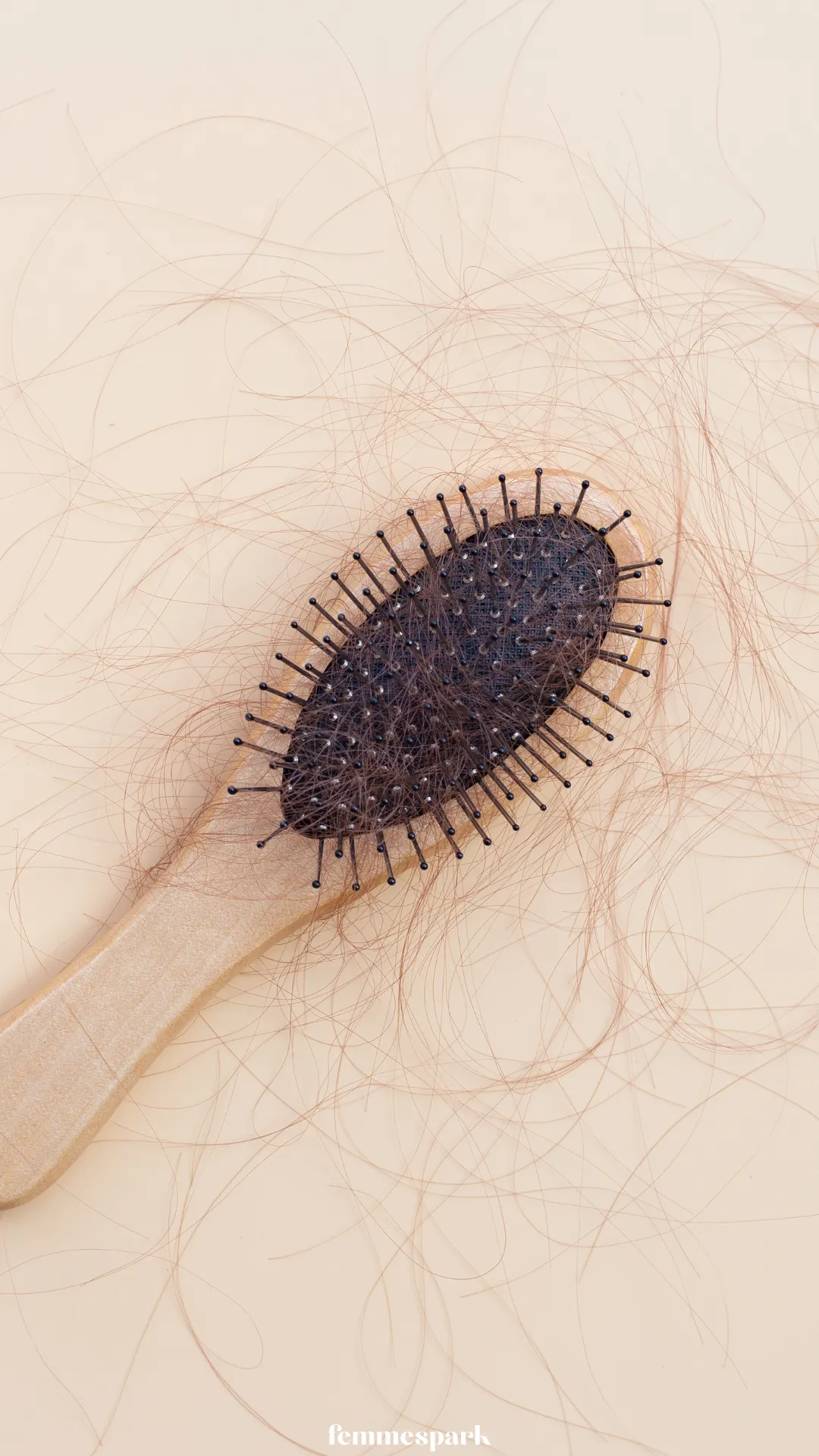 A hairbrush with a significant amount of shedded hair, visually representing postpartum hair loss and telogen effluvium.
